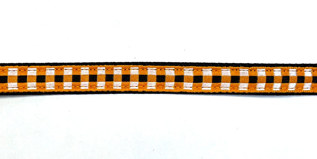 Black webbing dog collar with orange, black, and white plaid ribbon