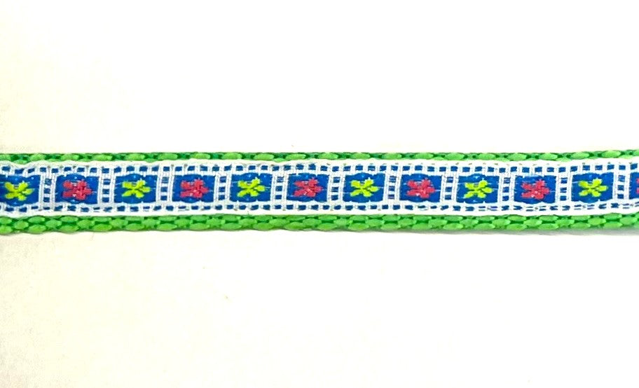 White ribbon with blue squares and pink and green flowers dog collar on green webbing