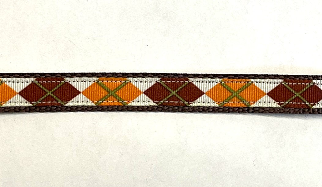 White ribbon with orange, burgundy, and olive green argyle design on brown webbing dog collar