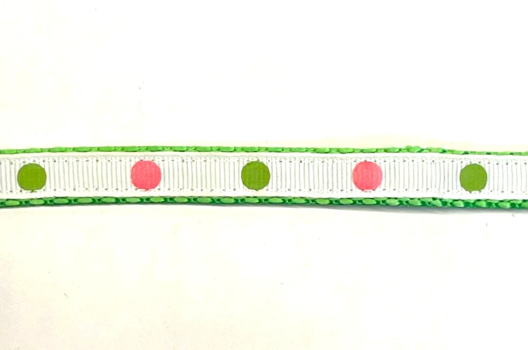 White ribbon with alternating pink and green dots dog collar on green webbing